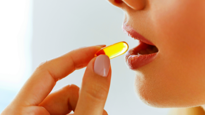 woman taking fish oil capsule