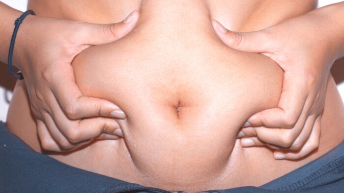 woman grabbing belly fat