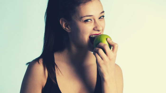 Woman eating green apple