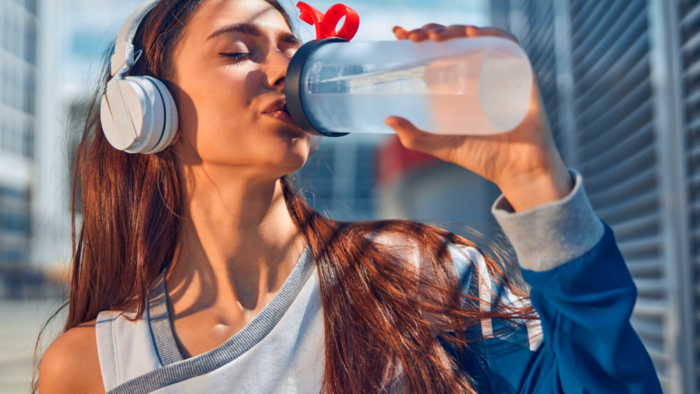 woman drinking water to raise metabolism