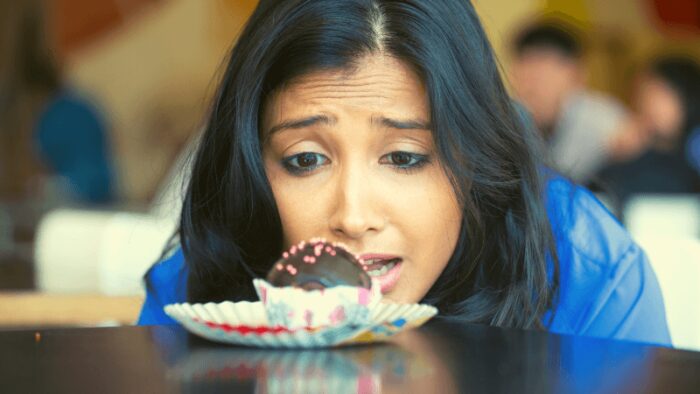 woman craving sugar laden donut