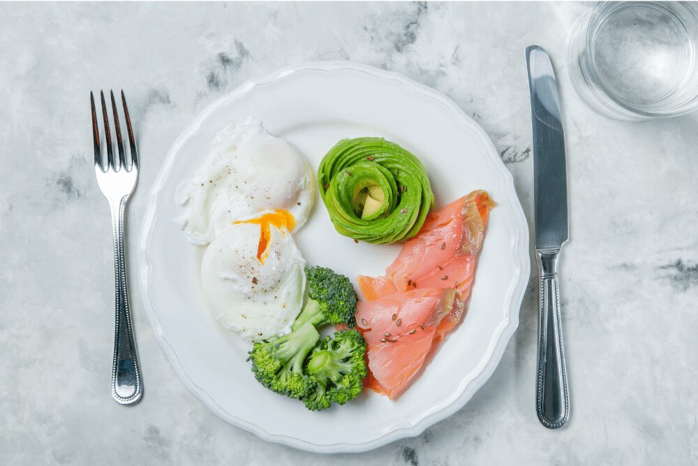 Keto breakfast of salmon, avocado, eggs and broccoli