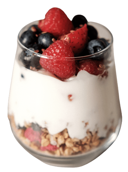 Glass cup of yogurt with strawberries, blueberries, and granola