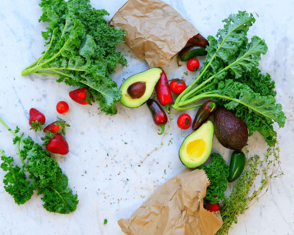 kale, avocados, strawberries and berries on table