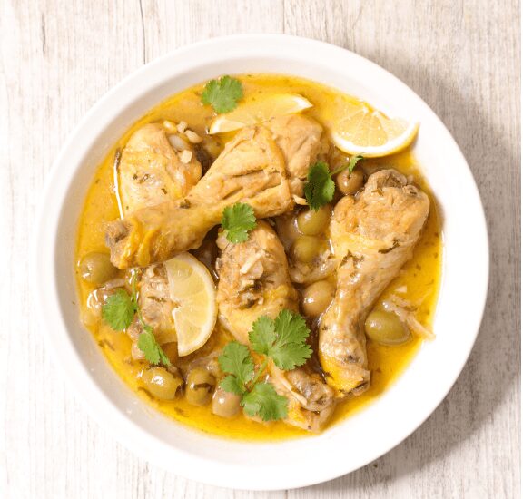 plate chicken with lemon and olives in sauce
