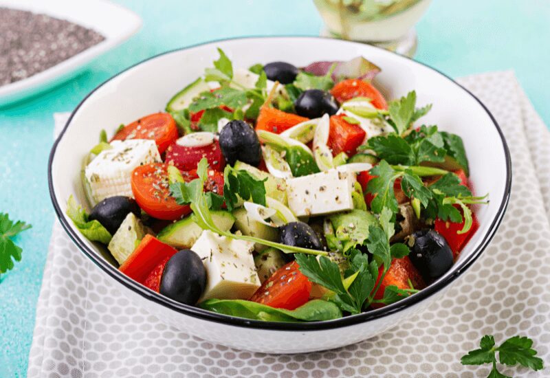 greek salad with feta cheese, kalamata olives, cucumbers, tomatoes, spinach