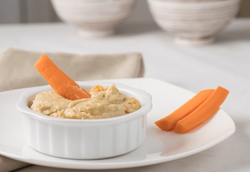 plate of hummus dip with a side of carrots