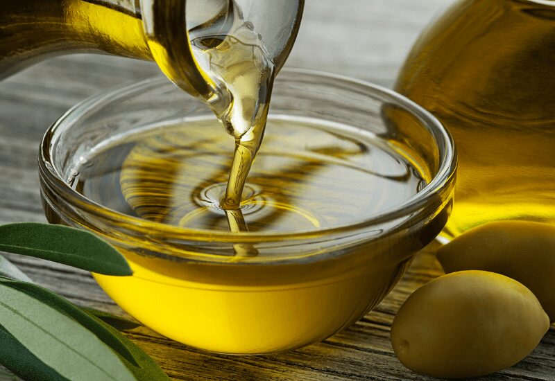 pouring olive oil into glass bowl