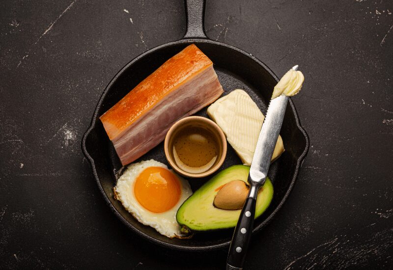 Foods for Keto Diet in Cast Iron Pan on Dark Background