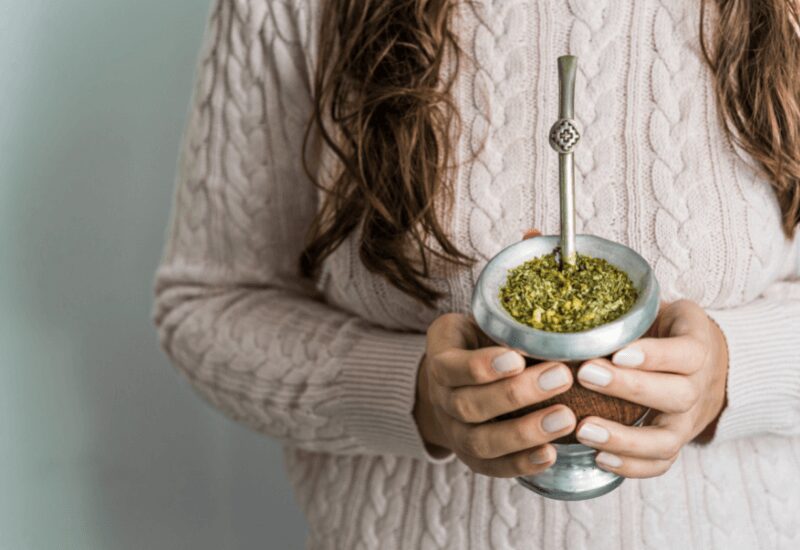 Young woman drinking traditional Argentinian yerba mate tea from a bombilla.