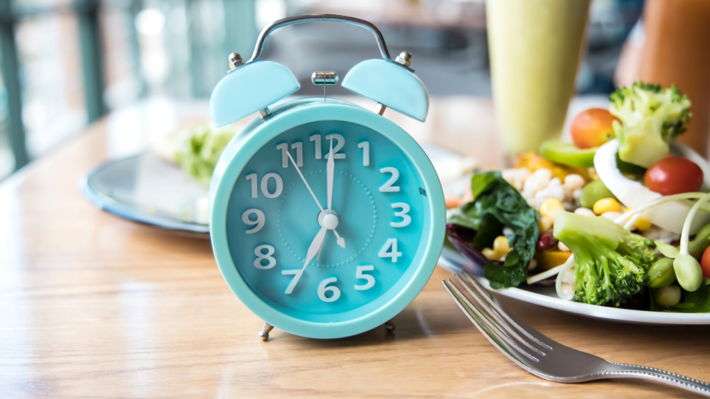 A clock and a bowl of salad.