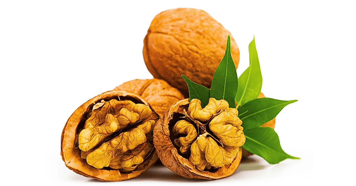 A trio of whole walnuts, each adorned with a lush leaf, accompanied by a close-up of one halved walnut revealing intricate details within. Set against a pristine white background.